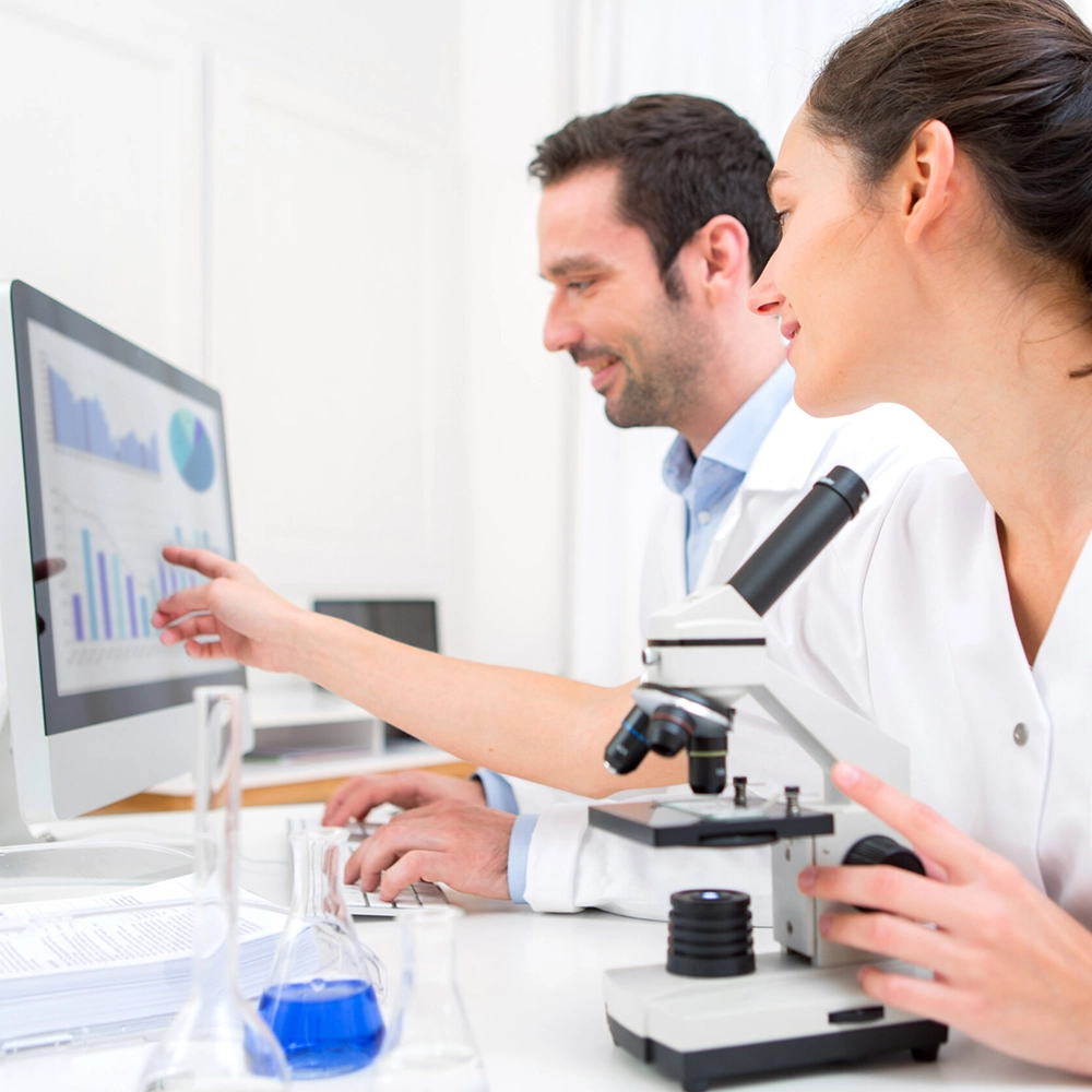 Medical researchers analyzing laboratory data with microscope and healthcare analytics dashboard
